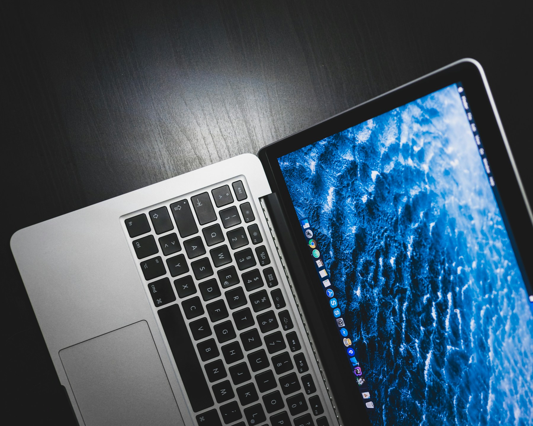 Silver Apple MacBook on a dark desk